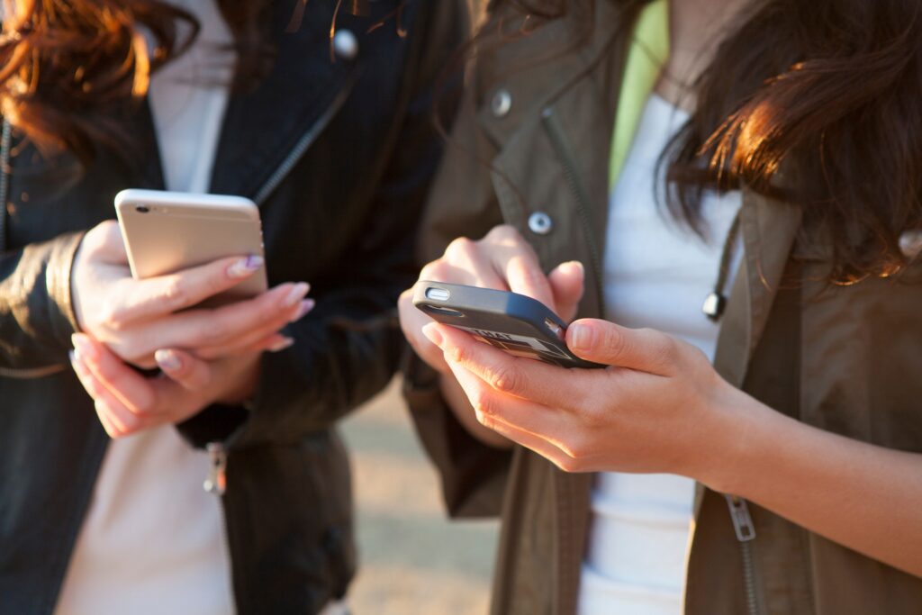 スマートフォンを持って操作している2人の女性